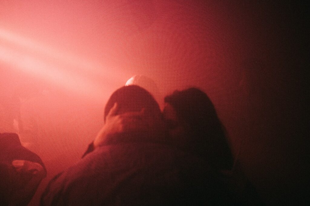 a group of people standing in front of a red light